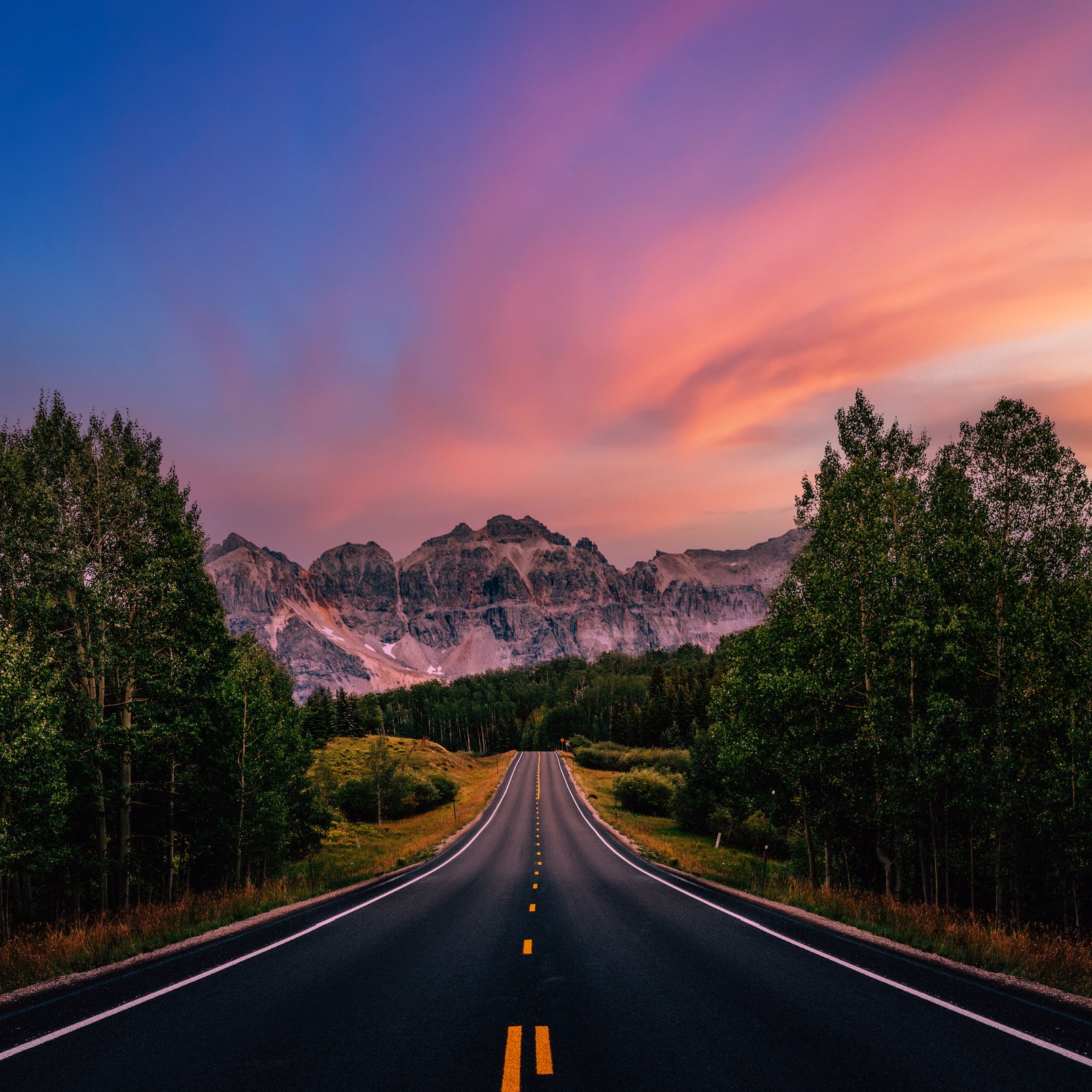 A long straight road leading towards mountains, Colorado, USA. Road trip, traveling vibes, freedom, courage.